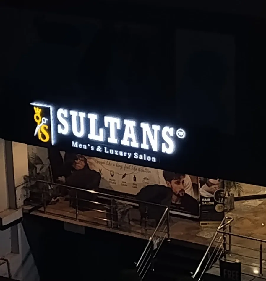 The lit SULTANS Men's & Luxury Salon sign above the shop at Civic Centre, Bahria Town Phase 4, at night
