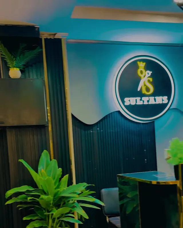 The lit Sultans crown logo on a dark fluted wall