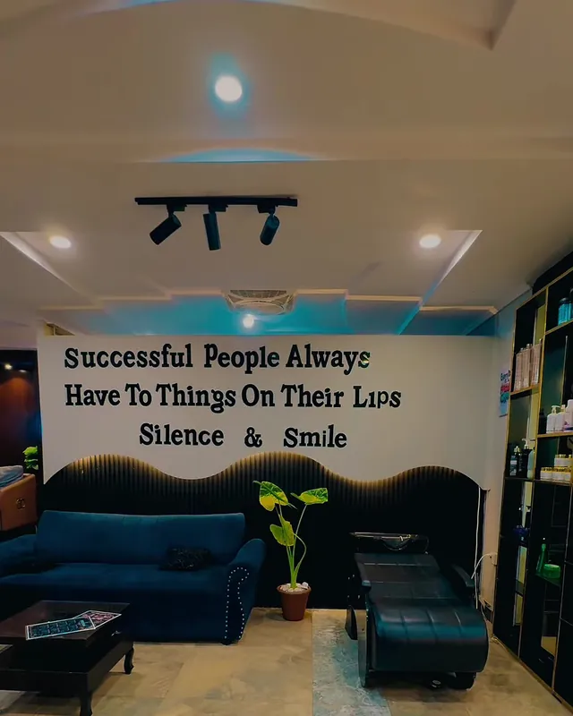 The waiting lounge with navy velvet sofas and a lettered quote wall